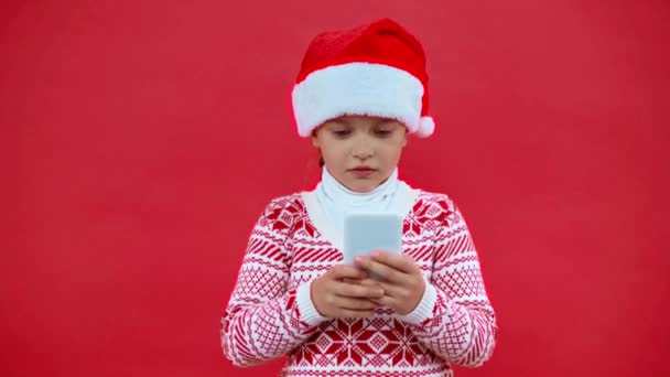 Girl Santa Hat Christmas Sweater Using Smartphone Isolated Red — Stock Video