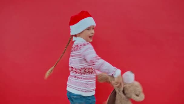 Dziewczyna Santa Kapelusz Boże Narodzenie Sweter Taniec Misiem Odizolowany Czerwono — Wideo stockowe