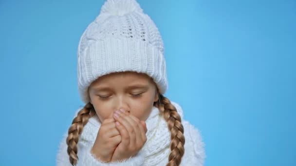 Дівчина Язаному Білому Зимовому Вбранні Кашляє Ізольовано Синьому — стокове відео