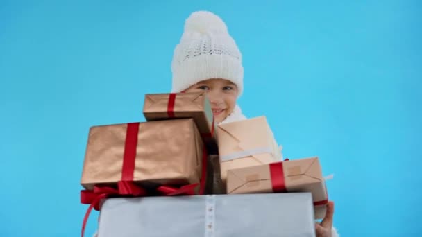 Mädchen Gestricktem Weißen Winteroutfit Mit Geschenkschachteln Isoliert Auf Blau — Stockvideo