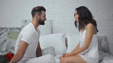 Mutlu bir adam yatak odasında, mutlu bir eşin arkasına saklanıyor. 