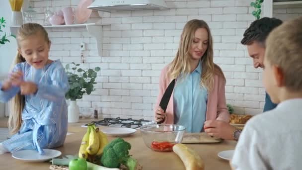 Sorrindo Mãe Cortando Tomate Perto Família Falando Perto Mesa Cozinha — Vídeo de Stock