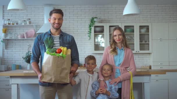 Família Sorridente Com Sacos Compras Olhando Para Câmera Cozinha — Vídeo de Stock