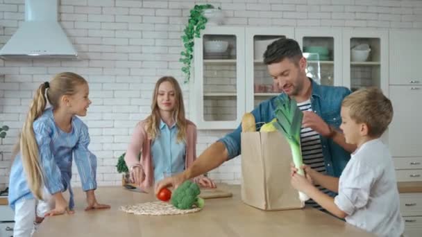 Irmãos Sorridentes Pai Desembalando Saco Compras Perto Mãe Cozinha — Vídeo de Stock