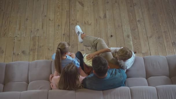 Κάτοψη Της Οικογένειας Τρώει Ποπ Κορν Ενώ Κάθεται Στον Καναπέ — Αρχείο Βίντεο