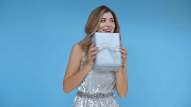 Mavi arka planda dans eden gülümseyen kadın 