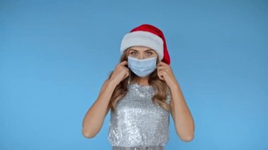 Noel Baba şapkalı bir kadın tıbbi maske fırlatıyor. 