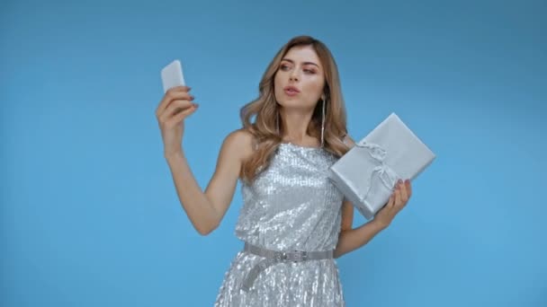 Gülümseyen Kadın Maviden Izole Edilmiş Akıllı Telefonuyla Selfie Çekiyor — Stok video