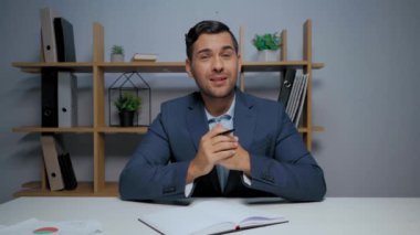Ofisteki video görüşmesi sırasında kağıt göstererek ve el kol hareketi yaparak mutlu yönetici