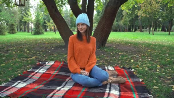 Uśmiechnięta Kobieta Stylowym Jesiennym Stroju Siedzi Kocu Parku — Wideo stockowe