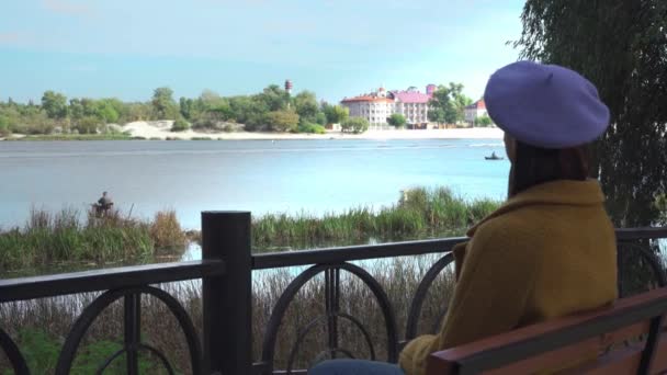 Junge Frau Sitzt Auf Brücke Park Und Blickt Auf Fluss — Stockvideo