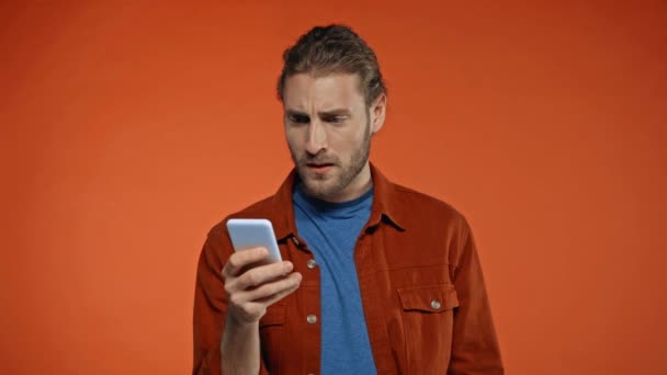 Ofendido Mensajería Del Hombre Teléfono Inteligente Aislado Naranja — Vídeos de Stock