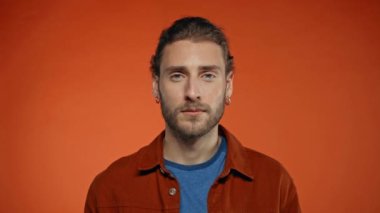 Sakin adam turuncu kameraya bakarken gülümsüyor.