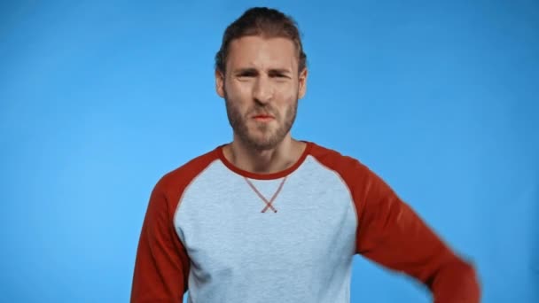 Podrážděný Muž Ukazuje Palce Dolů Jít Pryč Gesto Izolované Modré — Stock video