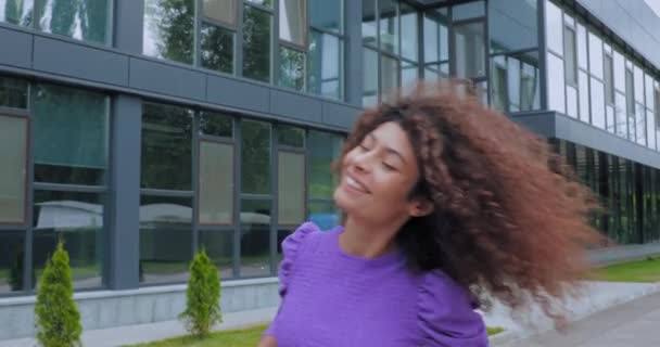 Mujer Emocionada Sonriendo Fijando Pelo Rizado Cerca Construcción — Vídeo de stock