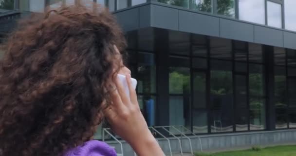 Krullend Jong Vrouw Praten Smartphone Buurt Van Gebouw — Stockvideo