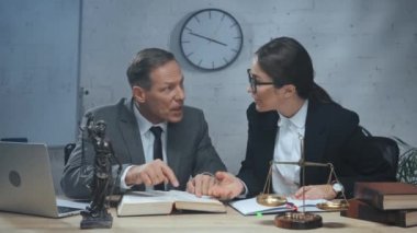 Ofiste çalışan avukatlar arıyor, kitap yazıyor ve konuşuyorlar. 