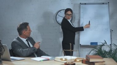 Sigorta acentesi çalışma masasının yanındaki çalışma masasına işaret ediyor. 