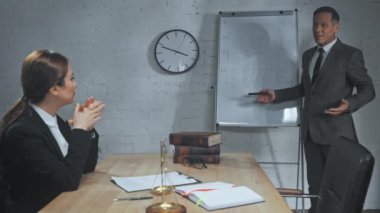 Gülümseyen sigorta acentesi ofiste meslektaşıyla konuşuyor. 