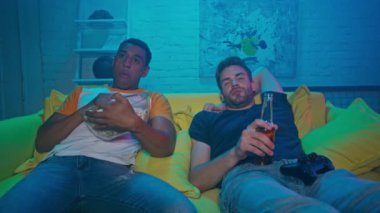 KYIV, UKRAINE - 20 Ekim 2020: Evdeki kanepede bira içen çok ırklı arkadaşlar