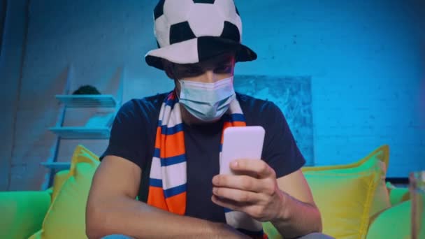 Football Fan Medical Mask Throwing Smartphone Home — Stock Video