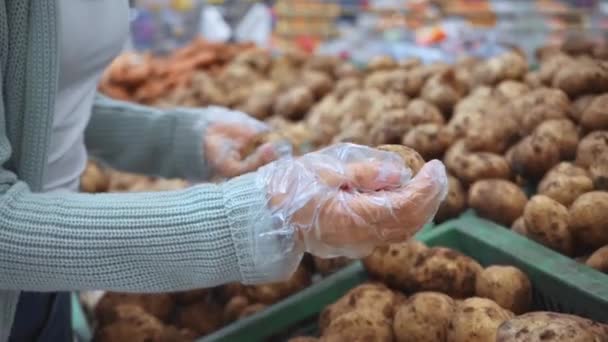 ジャガイモを選ぶポリエチレン手袋の女性のクロップドビュー — ストック動画
