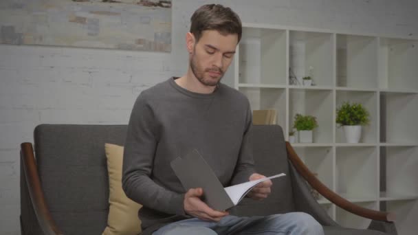 Δυσαρεστημένος Άνθρωπος Κοιτάζοντας Φάκελο Έγγραφα Στο Σπίτι — Αρχείο Βίντεο