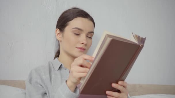 Tevreden Jonge Vrouw Omslaan Pagina Tijdens Het Lezen Boek Thuis — Stockvideo