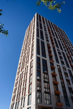 Açık mavi gökyüzüne karşı modern apartman binası. Yeni apartman blokları. Modern konut inşaatı. Aşağıdan görüntüle
