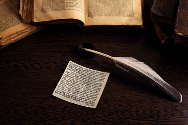 Mezuzah 'ın İbranice' de Yahudi duası Shema Yisrael 'in İngilizce' ye çevirisi İncil 'in emirlerinin listesi, arka planda Tevrat' ın tüyü ve açılışı. Alçak tuş