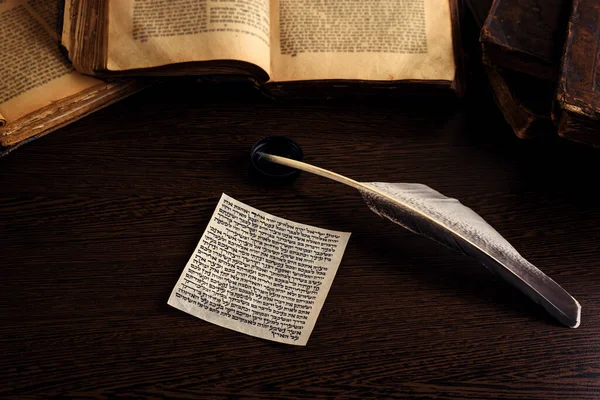 Mezuzah 'ın İbranice' de Yahudi duası Shema Yisrael 'in İngilizce' ye çevirisi İncil 'in emirlerinin listesi, arka planda Tevrat' ın tüyü ve açılışı. Alçak tuş