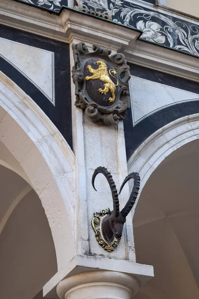 Column of building with a golden lion and a deer head with antlers in Europe