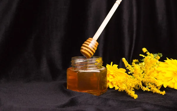 Пчелиный Мед Капает Деревянной Лопатки Стеклянную Банку Желтые Цветы Черный — стоковое фото