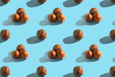 Mavi arka planda fındıklar, kusursuz desenler, sert gölgeler. Sağlıklı vejetaryen yemekleri, tasarım geçmişi.