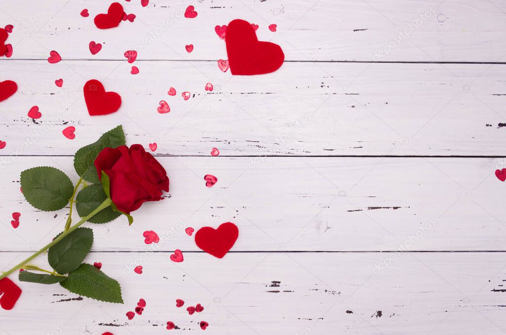 Rose and red hearts on a white wooden background, top view. Copyspace, a Valentine's Day concept.