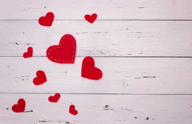 Beyaz ahşap arka planda kırmızı kalpler. Üst görünüm, metin için boş alan. Sevgililer Günü, aşkım..