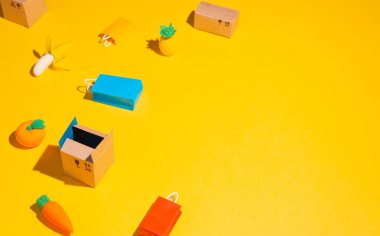 Small boxes, fruits and packages on a yellow background. Free space for text