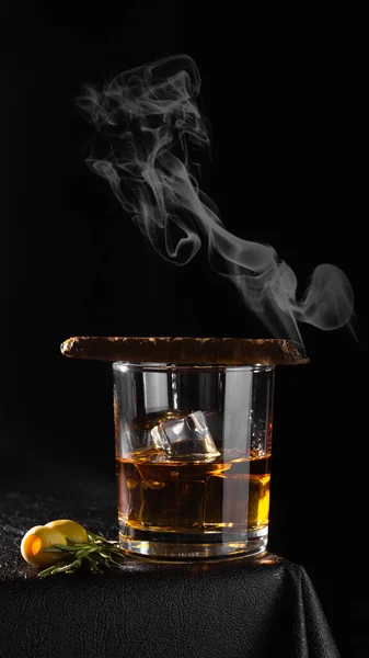 黒の背景のガラスのコニャック ラム酒 ウイスキーまたは他のアルコール飲料 ガラスの上の葉巻 — ストック写真