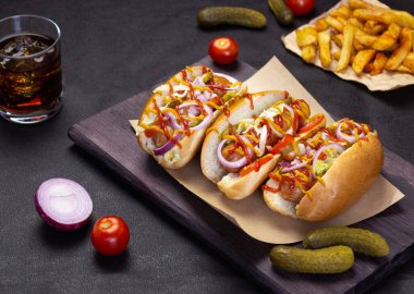 Sebzeli sosisli sandviç, hardal ve ketçap kesim tahtasında, yan manzara fast food, sokak yemeği.