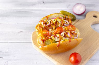 Sebzeli sosisli sandviç, hardal ve ketçap kesim tahtası, yan manzara Fast food, sokak yemeği, kopyalama alanı.