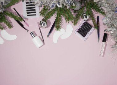 New year and Christmas for the masters of eyelash extension. Things for the work of lashmakers, artificial eyelashes, tweezers, combs, brushes for extended eyelashes. Top view, pink background, free space for text. clipart