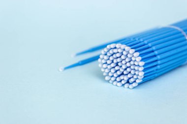 Mavi mikrofırınlar, kirpikleri ve dişleri temizlemek için küçük fırçalar. Mavi arka plan. Diş sağlığı, kirpik uzantıları.