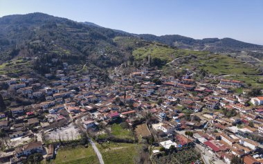 Türkiye 'nin İzmir kentindeki Sirince hava aracı görüntüsü, geleneksel taş ve ahşap evler, dar sokaklar, üzüm bağları ve yukarıdan manzaralı yamaçlar sergiliyor.