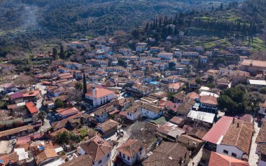 Türkiye 'nin İzmir kentindeki Sirince hava aracı görüntüsü, geleneksel taş ve ahşap evler, dar sokaklar, üzüm bağları ve yukarıdan manzaralı yamaçlar sergiliyor.