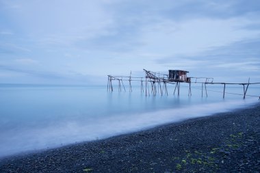 İskele ve pürüzsüz okyanus güneş doğarken, eski ahşap iskele Balık tutma