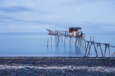 İskele ve pürüzsüz okyanus güneş doğarken, eski ahşap iskele Balık tutma