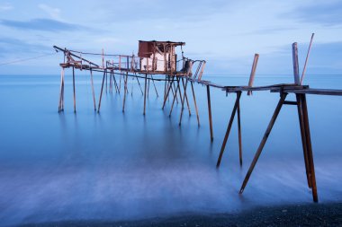 İskele ve pürüzsüz okyanus güneş doğarken, eski ahşap iskele Balık tutma