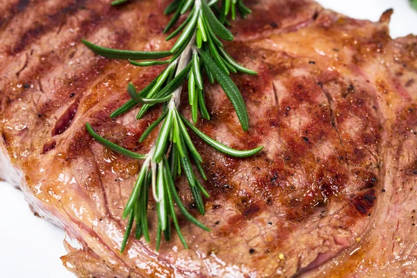 Delicious beef steak with rosemary bunch. — Stock Photo, Image