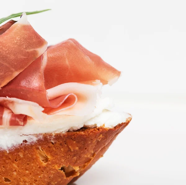 Prosciutto bruschetta z ricottą i rukolą. — Zdjęcie stockowe