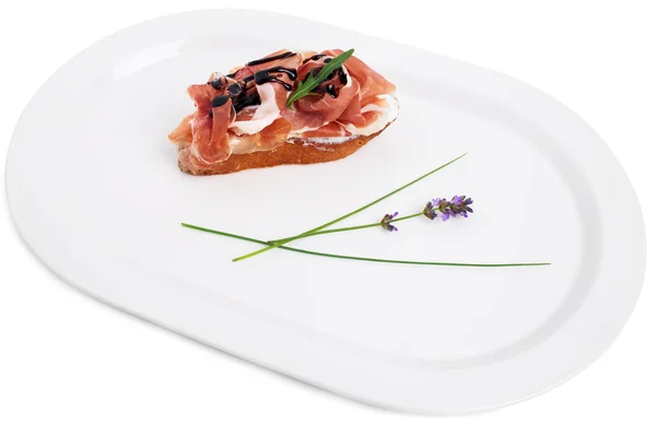 Prosciutto bruschetta s ricottou a rukolou. — Stock fotografie